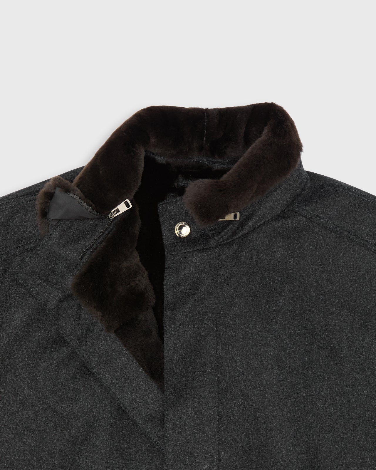 Close-up of a dark charcoal gray cashmere coat featuring a removable, plush dark brown fur collar and a silver snap button closure.
