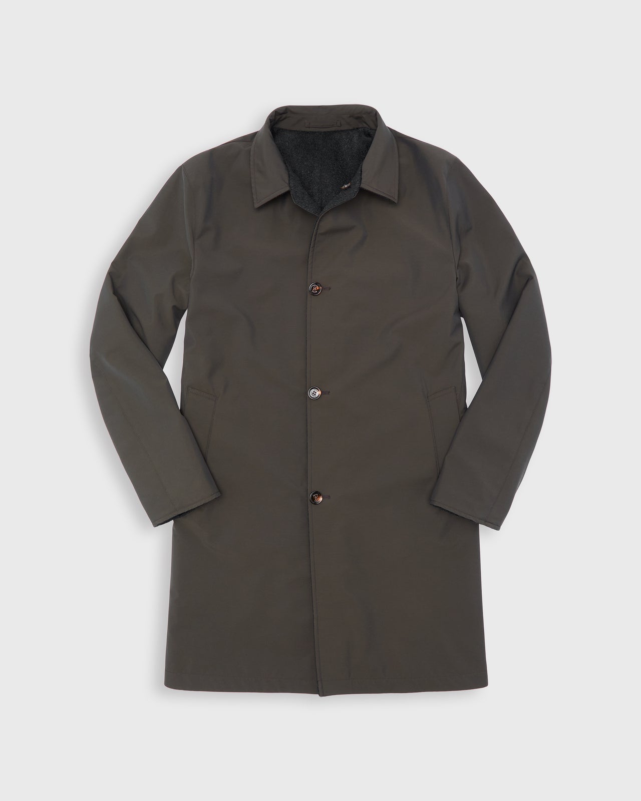A reversible dark brown wool and nylon water resistant utility coat with a pointed collar, button front, and side pockets, displayed flat against a light gray background.