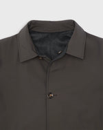 Load image into Gallery viewer, Close-up of a dark brown collared jacket with a dark gray cashmere reversible lining and a single breasted closure, shown against a light gray background.
